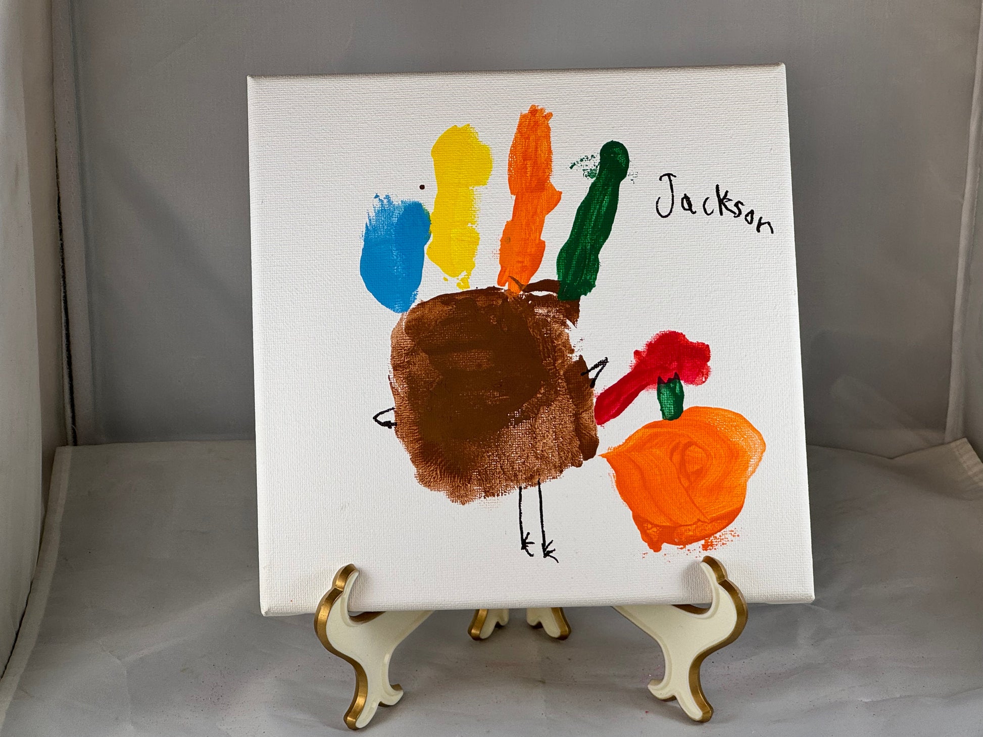 Kid art for sale to help those in need. Pictured "Hand Turkey" by Jackson, Cub Scout Pack 684 (Canvas, 8" x 8")
